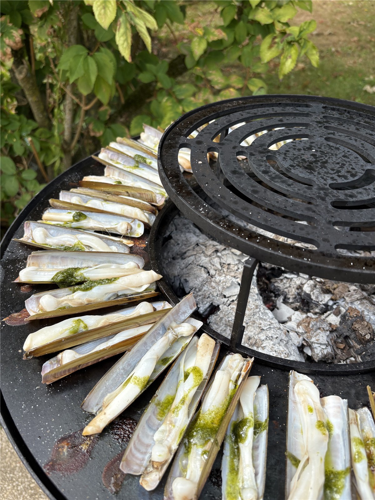 Cuisson de couteaux de mer au brasero traiteur extérieur